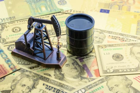 Un baril et un puit de pétrole sur un tapis de dollars